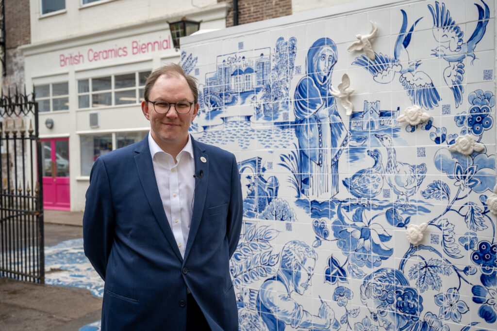 Gareth Snell MP stood outside the British Ceramics Biennial in front of their display ceramics wall.