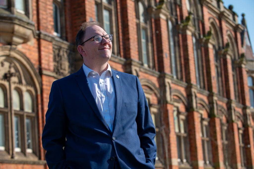 Gareth Snell MP stood outside of a building looking up into the sky
