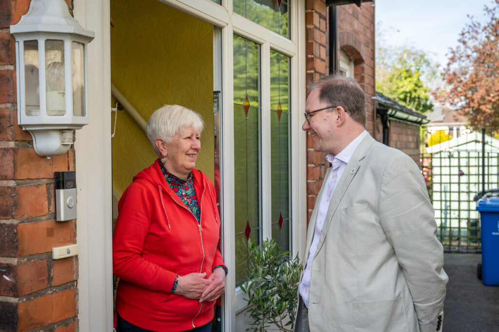 Gareth Snell MP speaking to a member of the public at their doorstep, both are seen to be smiling at each other.