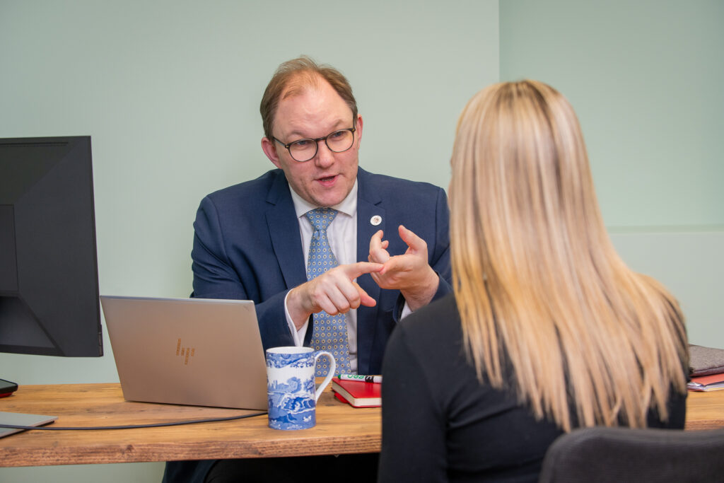 Gareth Snell MP sat at his desk speaking to a member of the public but he is seen to be counting on his fingers.